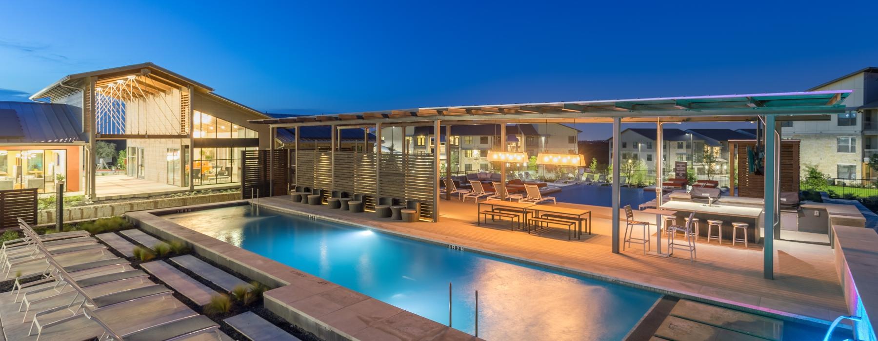 swimming pool lit at night with fountains
