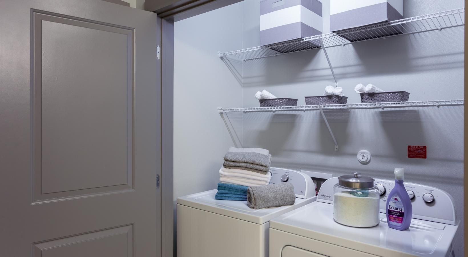 Laundry has never been easier side-by-side washer/dryer units in large laundry closet with light