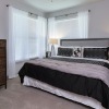 large, carpeted bedroom with windows