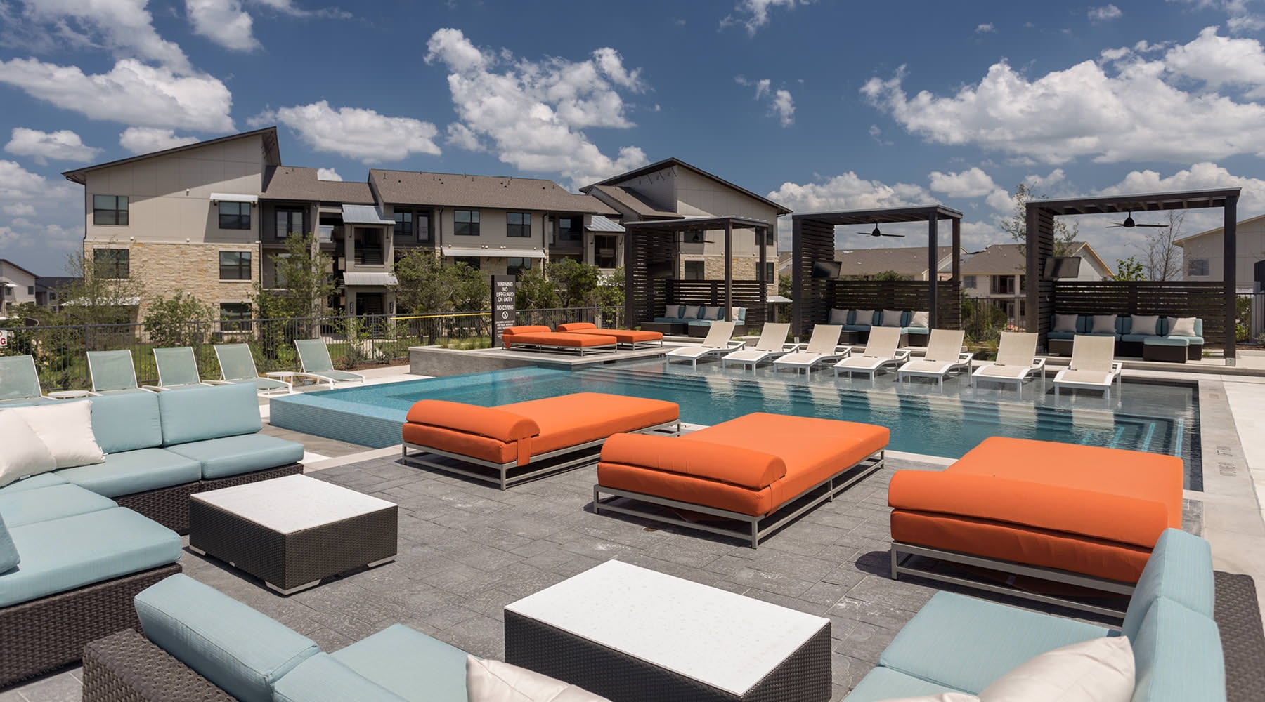Resort-style swimming pool lounge deck next to pool