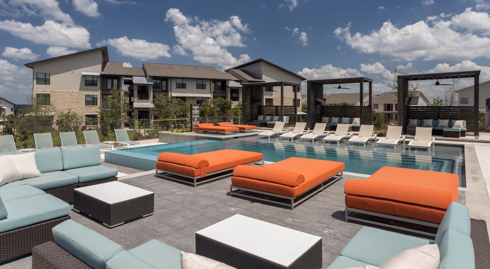 Resort-style swimming pool lounge deck next to pool