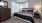 large, carpeted bedroom with windows